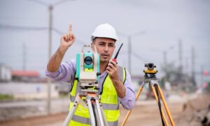 Land surveyor using total station during a topo survey for a Complete Streets project