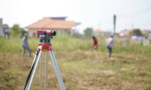 Survey equipment set up on vacant land during an ALTA land title survey before property closing