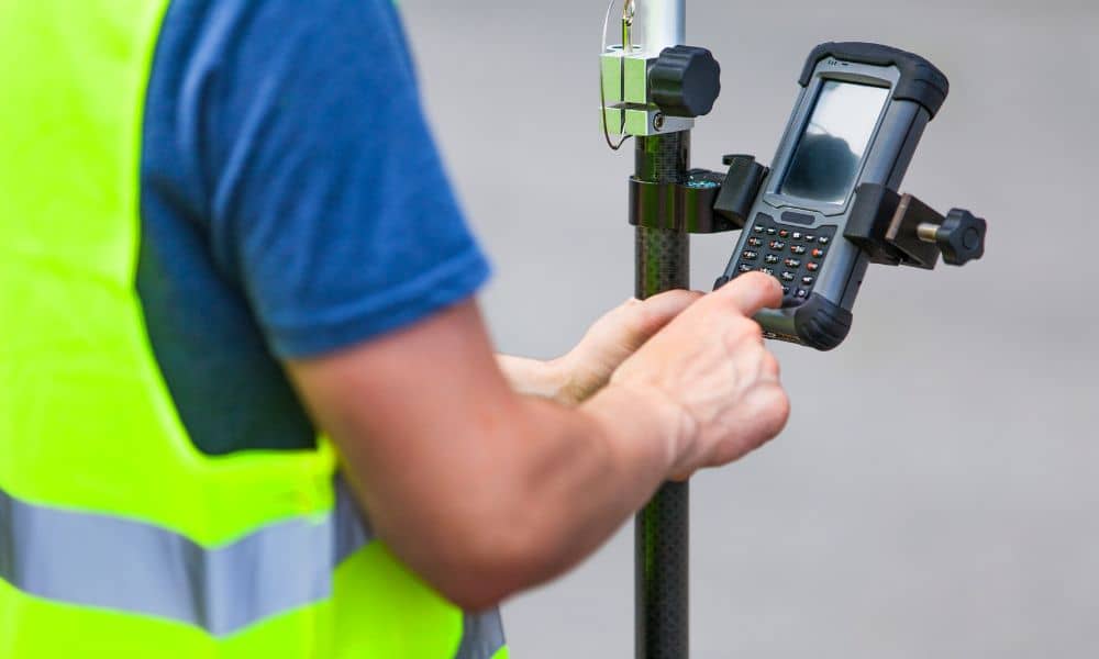 Land surveyor using RTK GPS equipment to record property data, showing why an ALTA Land Title Survey provides certified accuracy and legal assurance