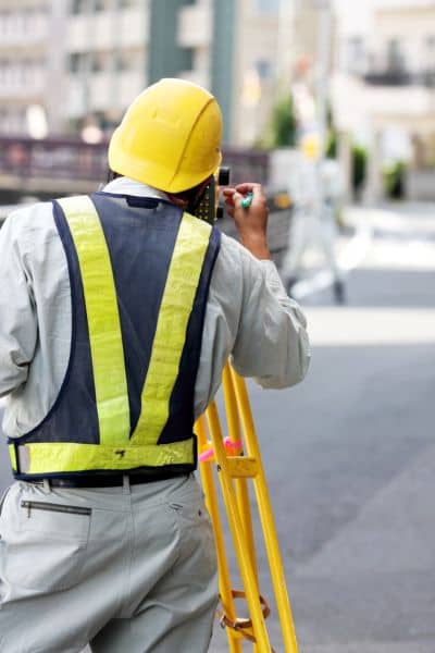 Surveyor taking site- measurements - ALTA SURVEY Georgia A land surveyor using field equipment to measure terrain accurately, showing how a topo survey helps identify ground issues before construction