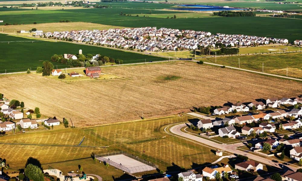 Aerial view of land transitioning into a new neighborhood, showing early subdivision design and site planning work