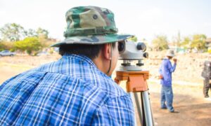 A land surveying professional measuring a site before infrastructure construction begins