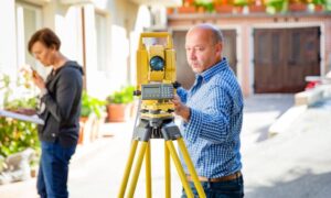 Historic district property measurement - ALTA SURVEY Georgia A surveyor performing land surveying work to verify property boundaries in a historic residential district