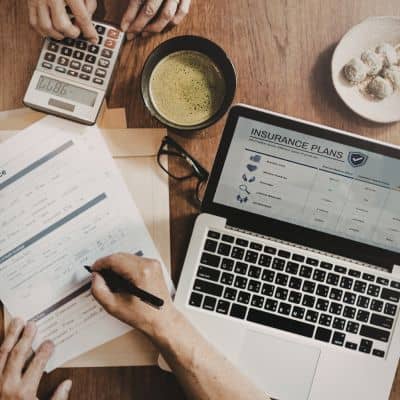 Homeowner reviewing flood insurance costs - ALTA SURVEY Georgia Homeowner reviewing flood insurance documents and calculating costs using elevation certificate data