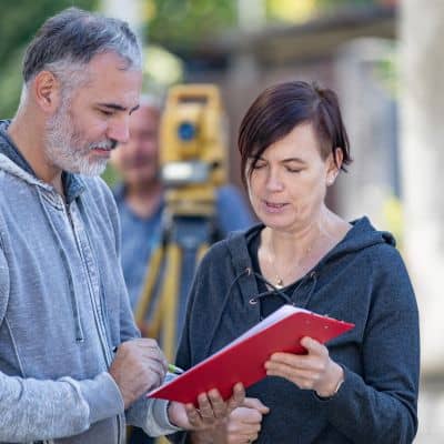 Licensed surveyor reviewing property records to explain the average cost for a land survey