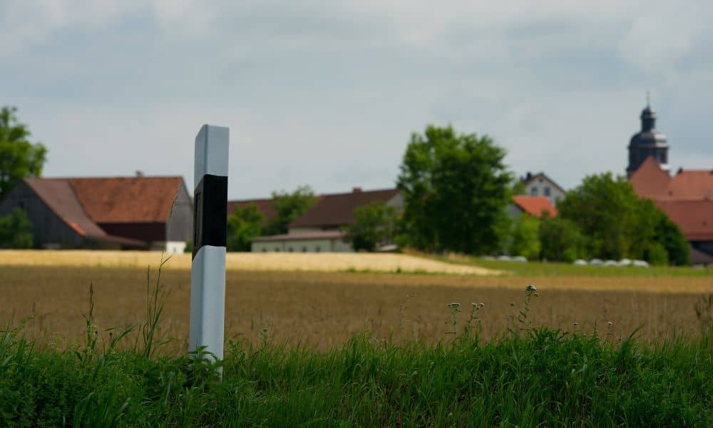 Boundary marker post field - ALTA SURVEY Georgia Property line survey marker post showing a land boundary near residential homes