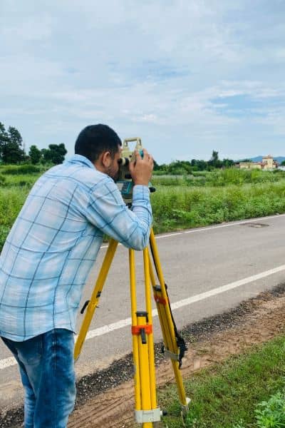 Land surveyor measuring property field - ALTA SURVEY Georgia Land surveyor using equipment to measure property lines before construction