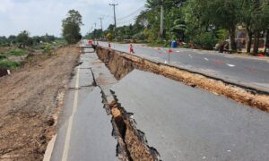 Road collapsed after heavy rain with soil erosion and cracks, showing why a topographic survey helps plan drainage
