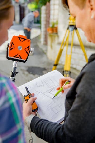 Residential surveyor reviewing property maps and boundary measurements for accuracy