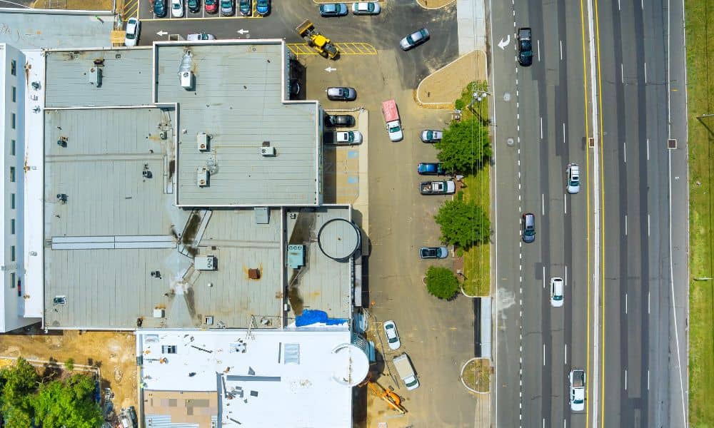 Aerial view of a commercial building, parking areas, and road access used to illustrate due diligence survey review before a property purchase