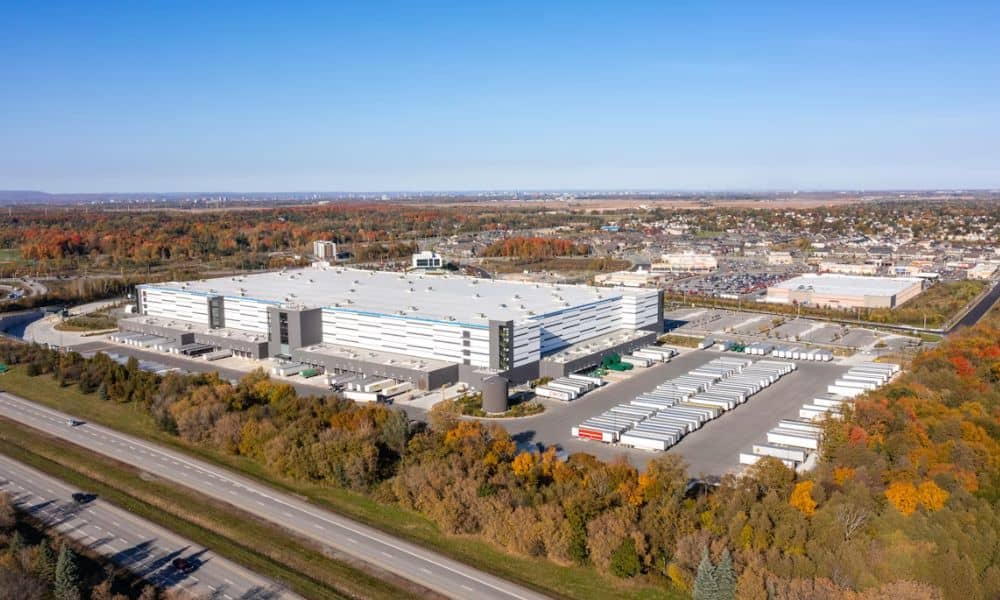 Aerial view of a large commercial property with an industrial building, parking areas, roads, and surrounding development associated with ALTA survey cost